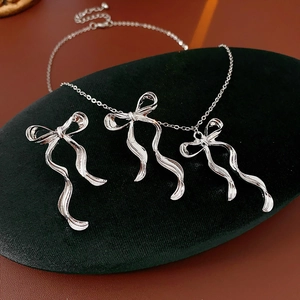 Vue détaillée d'une parure bijoux nœud argenté avec collier et boucles d'oreilles