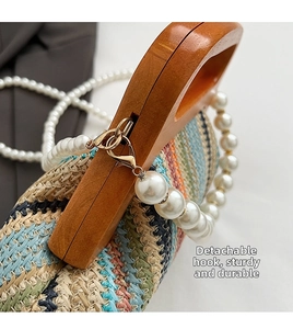 Detail of detachable pearl strap and durable metal clasp on the woven straw handbag