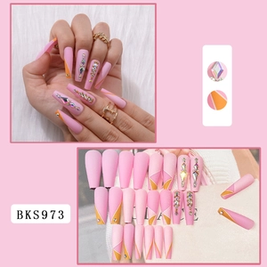 Detail of pink long coffin press-on nails with orange accents and inlaid rhinestones