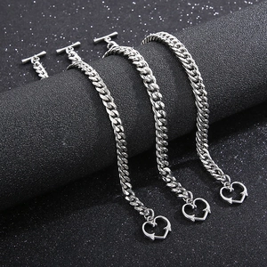 Détail du bracelet gourmette en acier titane argenté avec fermoir OT et pendentif coeur