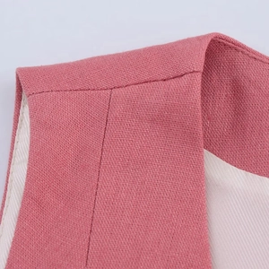 Detailed close-up of pink linen blend vest shoulder seams and fabric texture