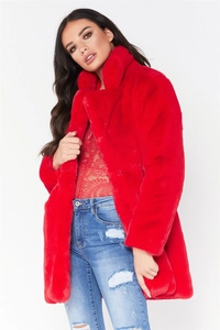 Détail d'un manteau en fausse fourrure rouge avec haut en dentelle et jean bleu