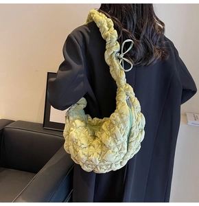 Detail of green quilted velvet hobo bag showing pleated strap and soft fabric texture
