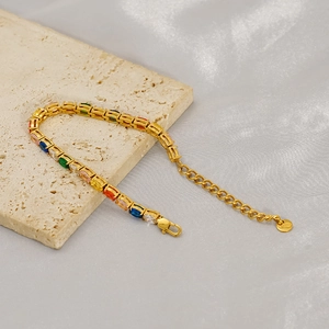 Dettaglio di un bracciale in acciaio dorato con pietre colorate a taglio rettangolare