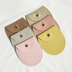 Flat lay of small PU leather jewelry snap pouches in six different vibrant colors