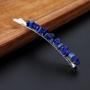 Detail of silver hair clip with handmade deep blue natural crystal stones on dark wood