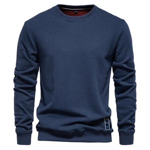 Detail showing the navy blue crewneck sweatshirt fabric and hem decorative label