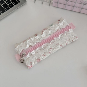 Detailed macro view of quilted floral pencil case with lace trim and flower zipper