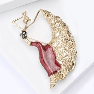 Detailed close-up of a golden dancing girl brooch with red enamel and crystal accents
