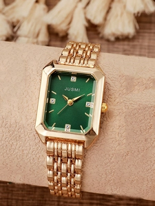 Macro shot of gold square quartz watch with emerald green dial and crystal markers
