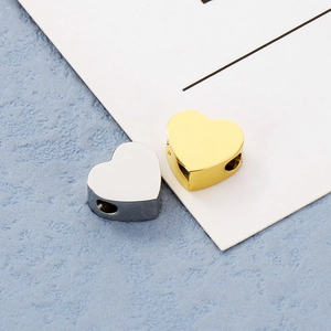 Vista macro di perline a forma di cuore in oro e argento con finitura lucida per i braccialetti