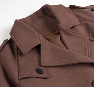 Détail du manteau en laine marron montrant le revers, l'épaulette et le bouton noir