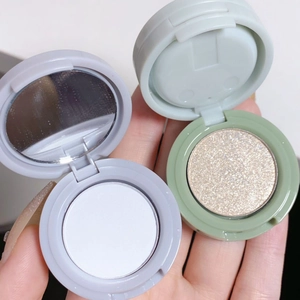 Vue rapprochée de palettes de maquillage avec poudre blanche mate et paillettes dorées