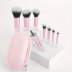 Peach pink 10pcs makeup brush set with oval zipper pouch on white geometric stand