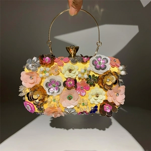 Detail view of handmade floral beaded evening clutch bag with colorful 3D flowers and metal handle
