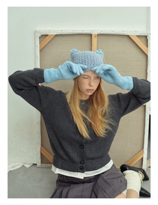 Close-up of blue wool blend knitted gloves and matching hat with a cute bow detail