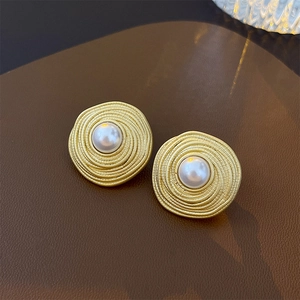 French vintage gold spiral earrings with white faux pearl insets on brown leather base