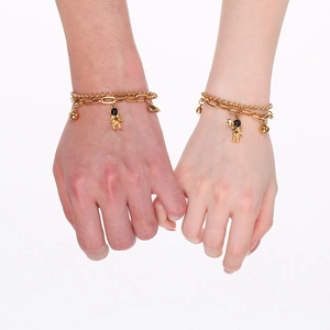 Detail of gold layered astronaut bracelet with magnetic heart on female wrist