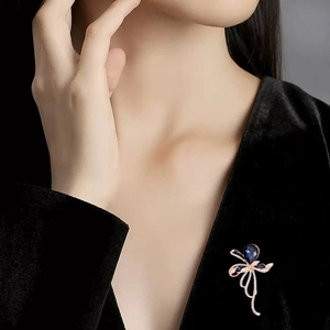 Elegant pear-shaped deep blue gemstone brooch with rose gold setting and crystal accents