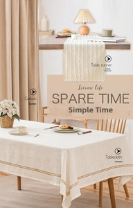 Detail showing linen tablecloth with woven borders and matching white striped table runner