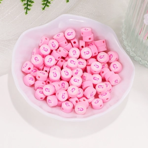 Perline in pasta sintetica rosa con motivi floreali bianchi in una ciotola bianca