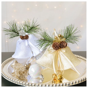 Detail of velvet Christmas bells with pine needles and pinecones on a silver tray