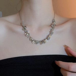 Detail of silver layered necklace with teardrop sequins on model's neckline