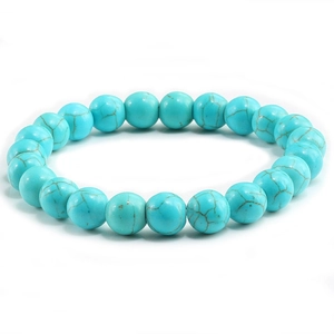 Detailed view of turquoise beaded bracelet with natural brown marble texture on white background