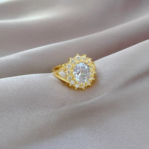 Macro shot of luxury gold ring with marquise cut diamond center stone on gray silk fabric