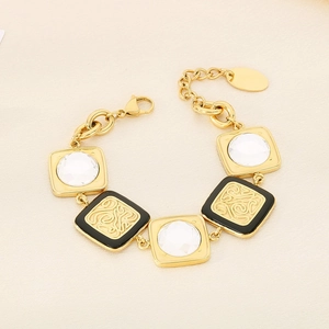 Dettaglio macro del bracciale geometrico dorato con pietre bianche e motivi in smalto nero