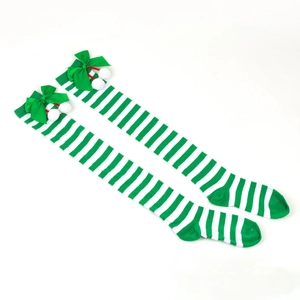 Detail of green and white striped Christmas over-knee socks with bows and fuzzy pom-poms