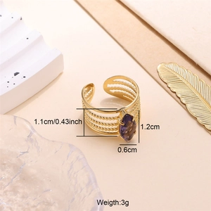 Dettaglio dell'anello multistrato dorato con zircone viola a forma di marquise