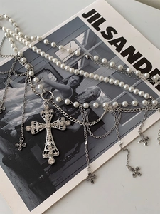 Détail d'une chaîne de corps perlée multicouche avec pendentif croix en strass