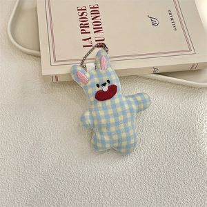 Close-up of blue and yellow checkered plush rabbit keychain with detailed embroidery