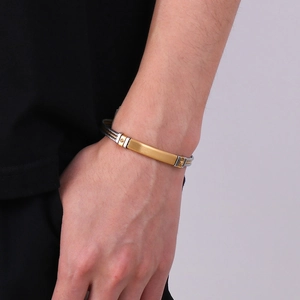 Detailed shot of two-tone braided stainless steel cable bracelet on male wrist