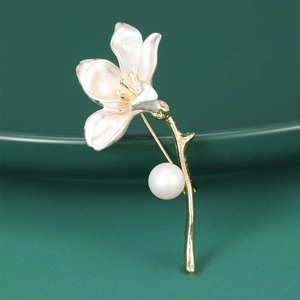 Detail of trumpet flower brooch with white petals, gold stem and a round pearl accent