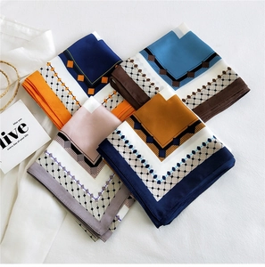 Detailed view of four silk square scarves with geometric patterns and satin finish