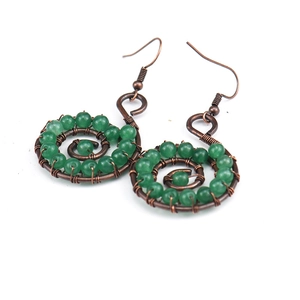 Detail of handmade copper wire wrapped green stone yoga earrings on white background