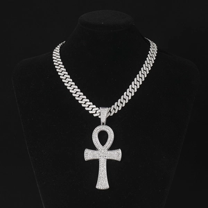 Détail macro du pendentif croix Ankh argenté avec strass brillants sur chaîne cubaine