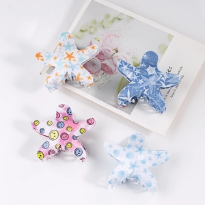 Set of four starfish hair claws with smiley patterns in blue, pink and yellow shades