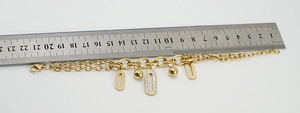 Dettaglio del bracciale in acciaio dorato con ciondolo in cristallo ovale e misura lunghezza