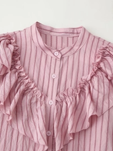 Detail of pink striped shirt showing ruffled collar and delicate button-down front texture