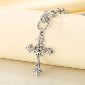 Detail of silver cross pendant with fleur-de-lis motif and dual mixed-link chain style