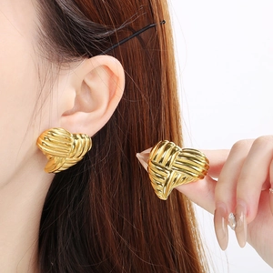 Detail of 18K gold-plated heart earrings with ribbed texture and pearl accents