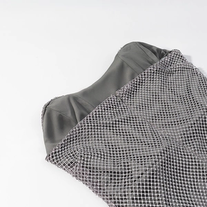 Détail du tissu en maille grise avec des strass étincelants sur une robe bustier chic