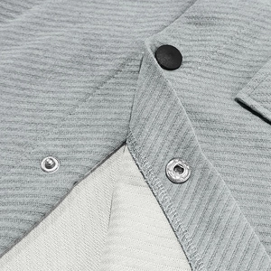 Detail of light gray heavy twill jacket showing premium snap button and ribbed fabric texture
