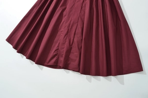 Detailed macro view of deep wine red pleated fabric texture on a French style summer dress