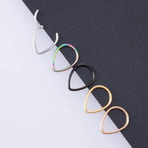 Macro detail of teardrop nose rings in silver, rainbow, black, gold and rose gold finishes