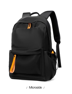 Detail view of the black waterproof backpack featuring vibrant orange zipper pulls and straps
