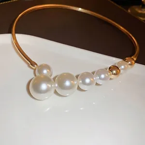 Collier ras de cou doré orné de perles élégantes disposées selon un motif géométrique